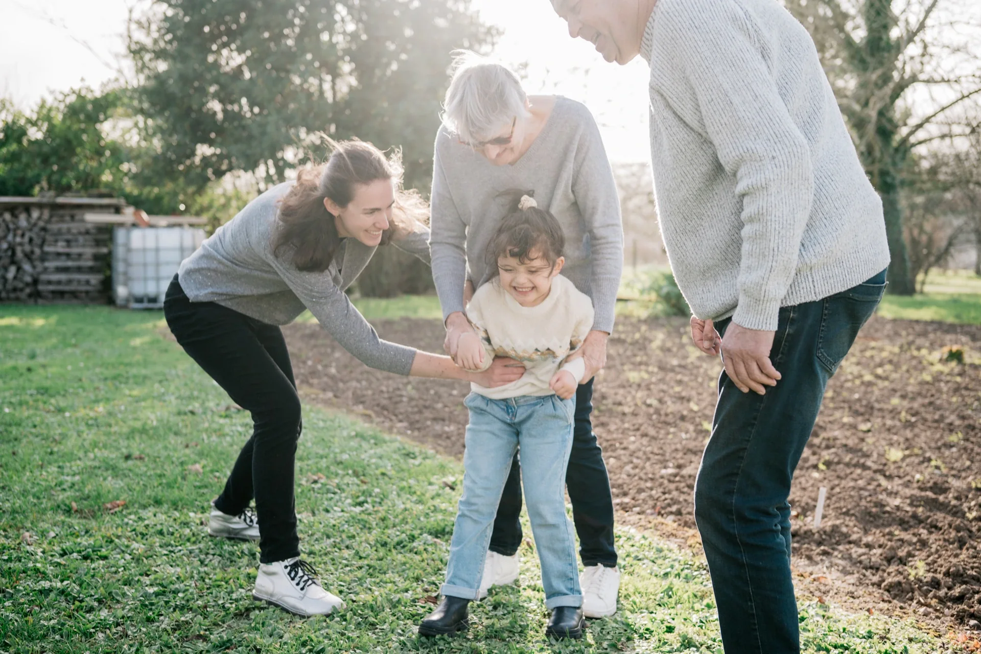 Grands-parents et petites-filles riant au jardin, séance photo famille à Marcillac-Lanville par Alexandre Topolewski