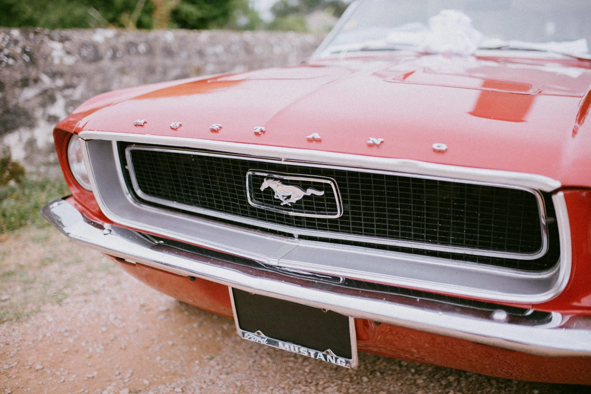 Détail de la calandre chromée et de l’emblème au cheval de la Mustang rouge
