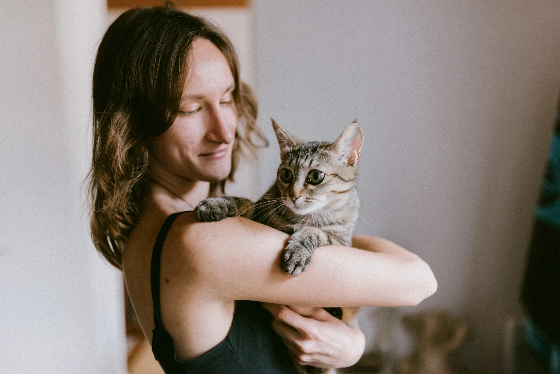 Portrait d'intérieur complice d'une jeune femme tenant son chat à Chasseneuil-sur-Bonnieure par Alexandre Topolewski
