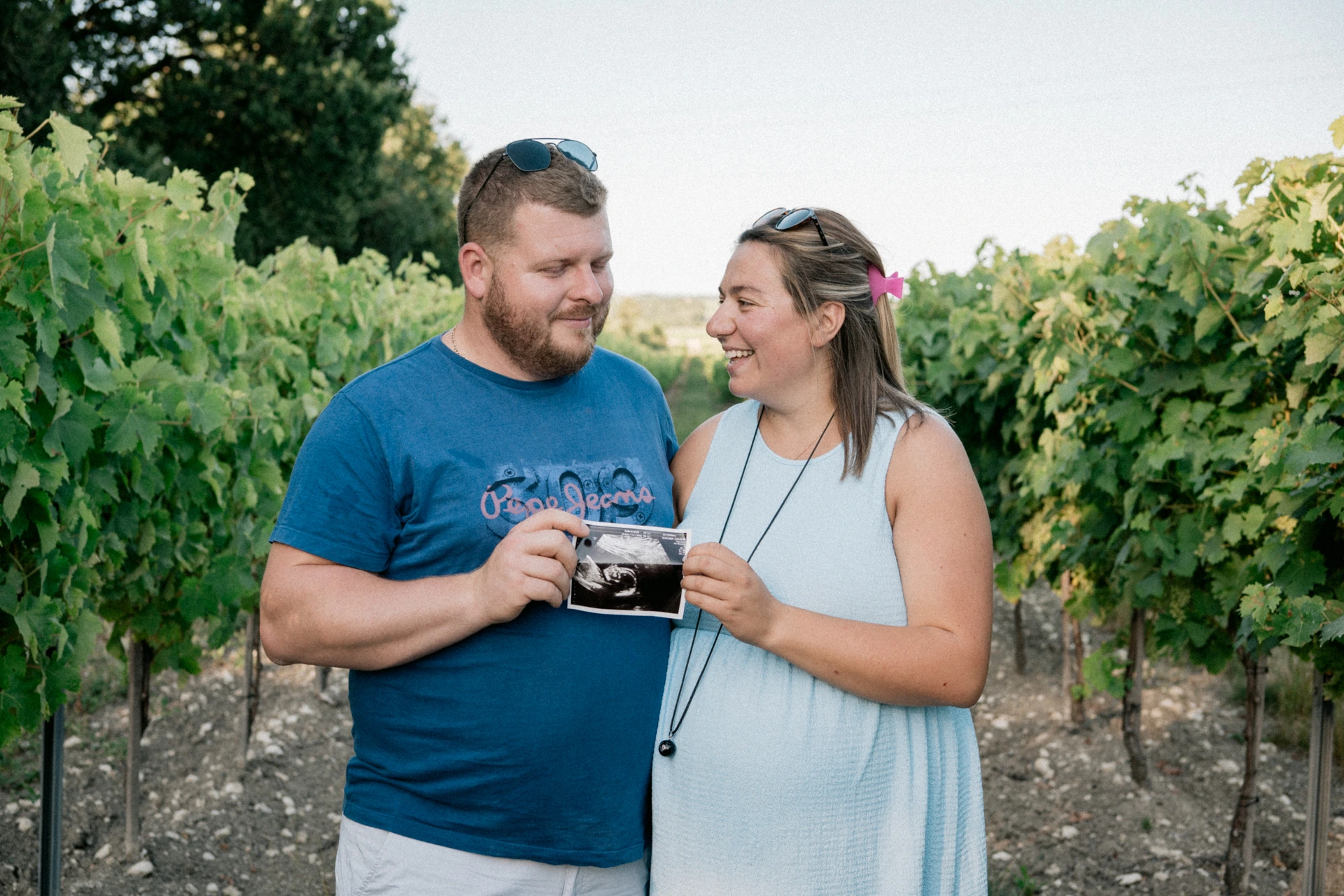 Séance photo grossesse dans les vignes à Bordeaux – futurs parents à Saint-Médard-en-Jalles et Le Taillan-Médoc tenant une échographie.
