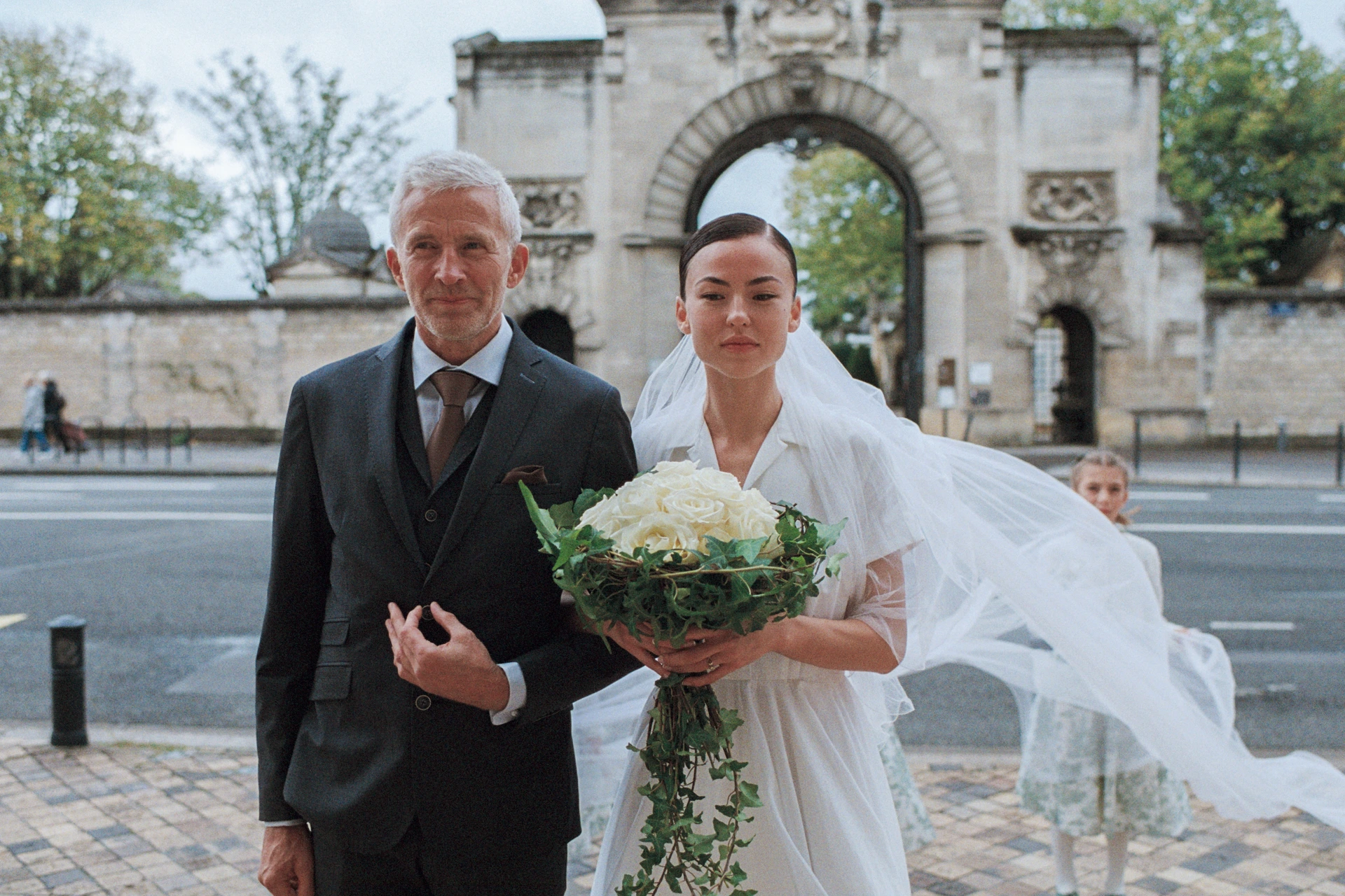 Mariée entrant à l’église Saint-Bruno à Bordeaux, photographiée en argentique aux côtés d’un proche
