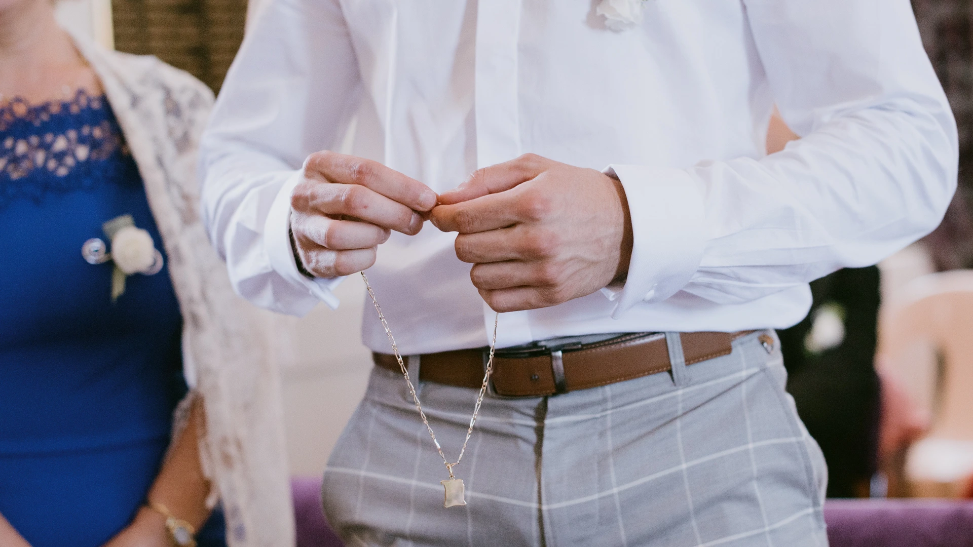 Détail photographique lors d’un baptême à Bordeaux, collier tenu entre les mains pendant la cérémonie à Saint-Médard-en-Jalles