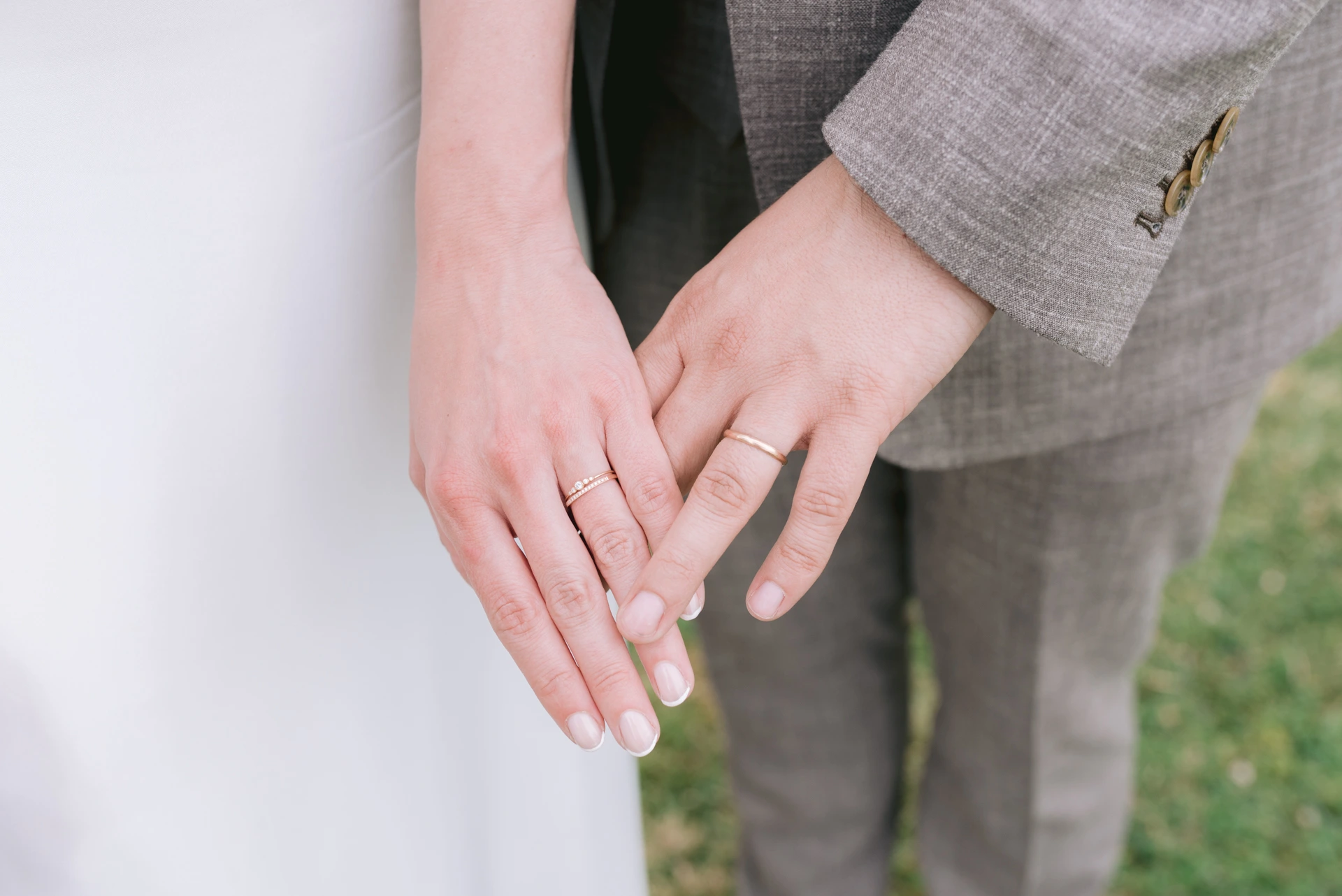 Détail des alliances lors d’un mariage fine art à Bordeaux, mains des mariés enlacées à Saint-Médard-en-Jalles