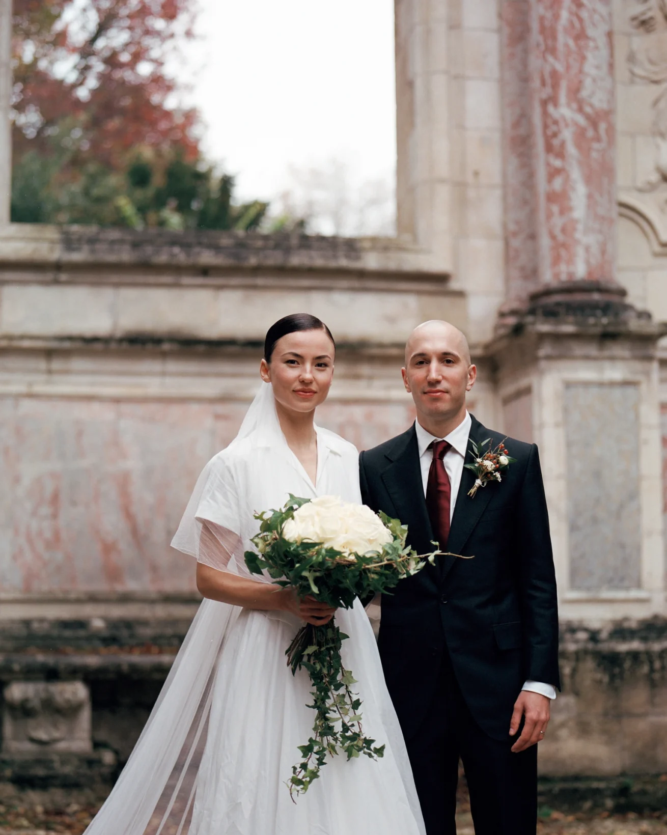 Portrait des mariés devant une architecture en pierre, photographie de mariage argentique au Château du Taillan, Bordeaux