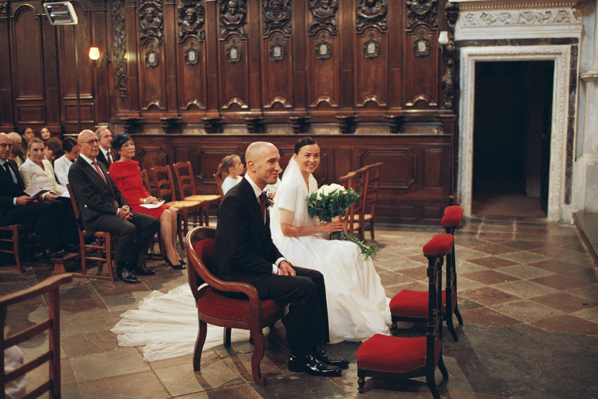 Photographie argentique de mariage dans l'église Saint-Bruno à Bordeaux, le couple de mariés assis devant l'autel durant la cérémonie.