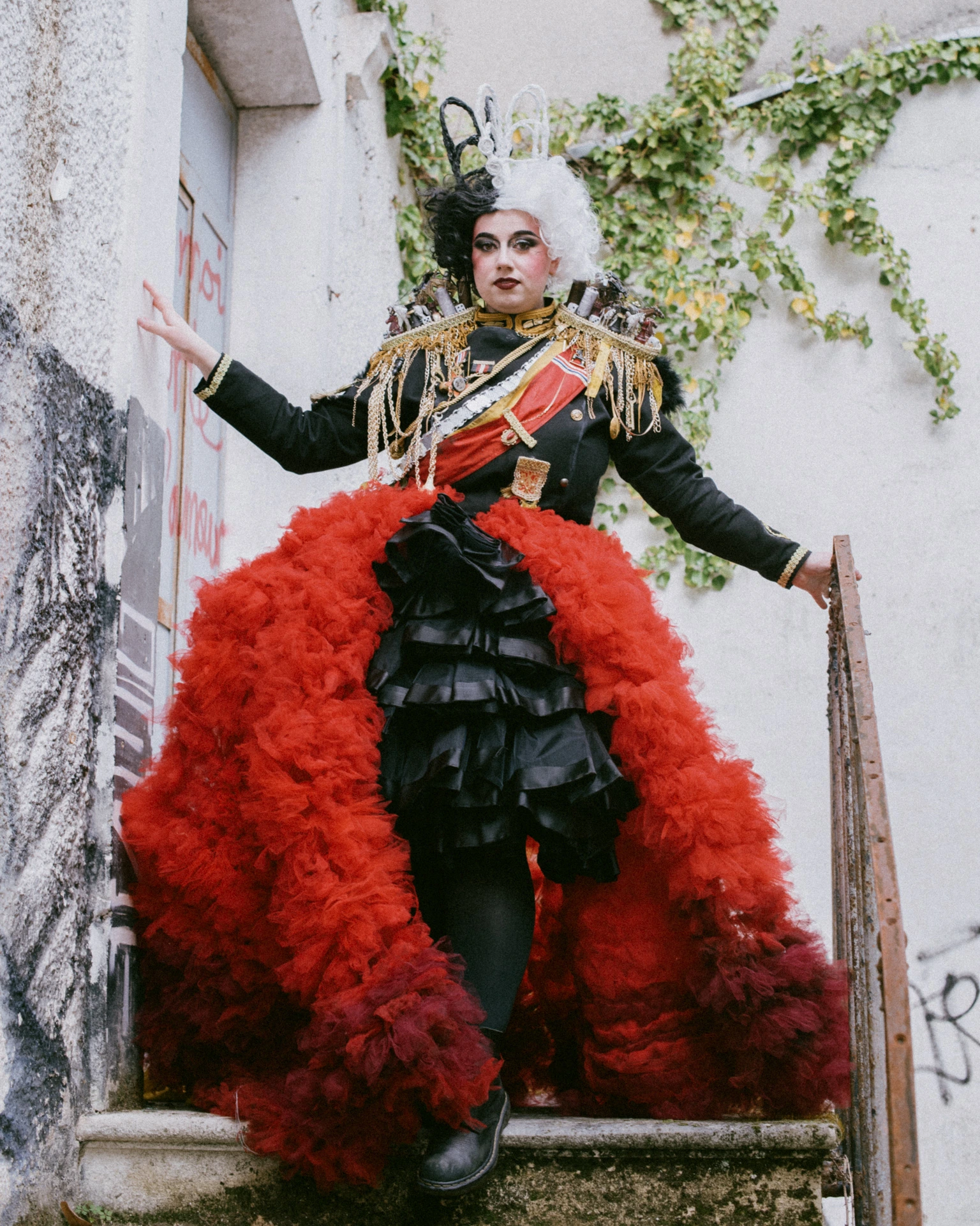 Cosplay Cruella d'Enfer descendant un escalier de pierre, bras écartés, éditorial Périgueux