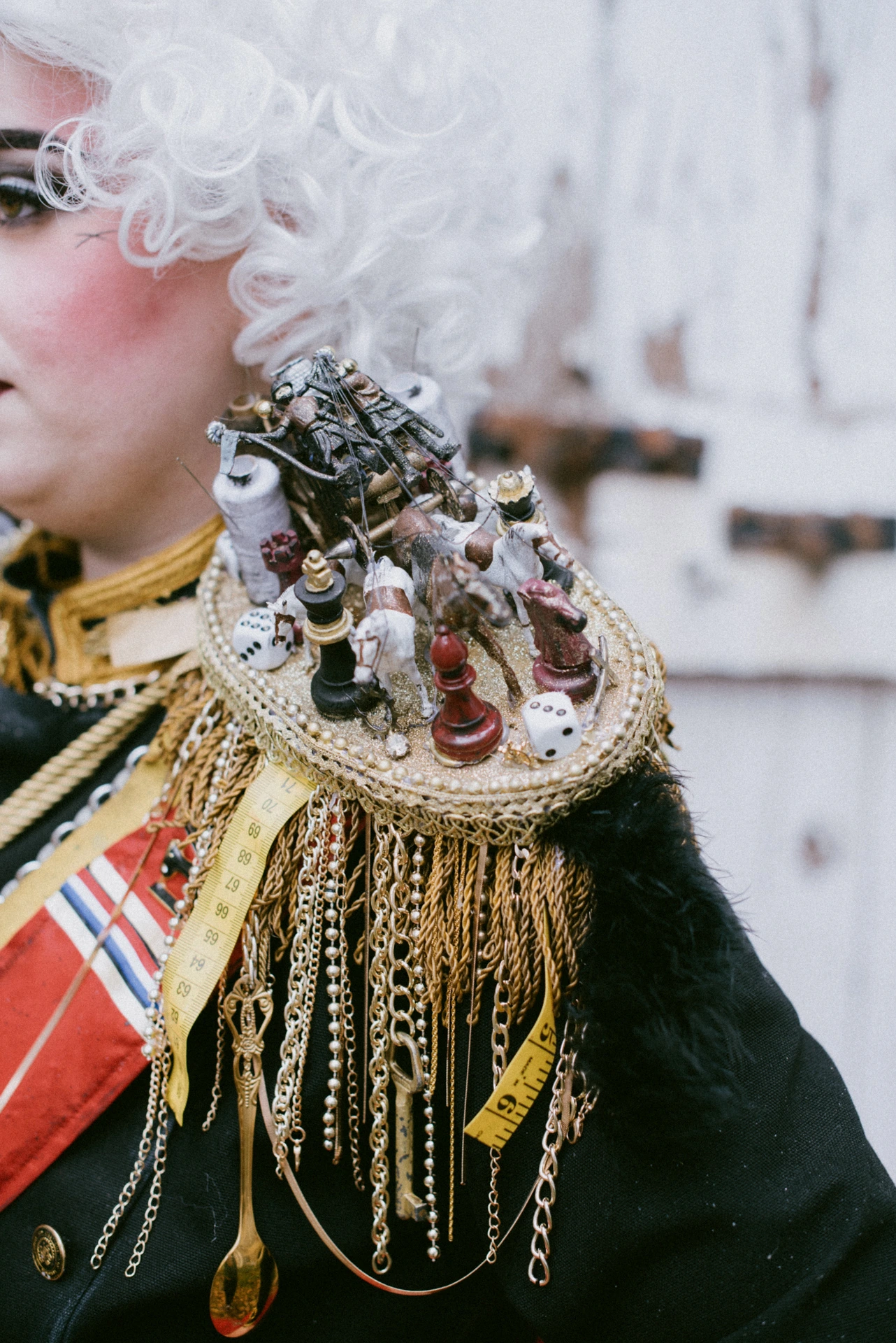 Détail de l'épaulette du costume Cruella d'Enfer, pièces d'échecs et chaînes dorées, cosplay éditorial Dordogne