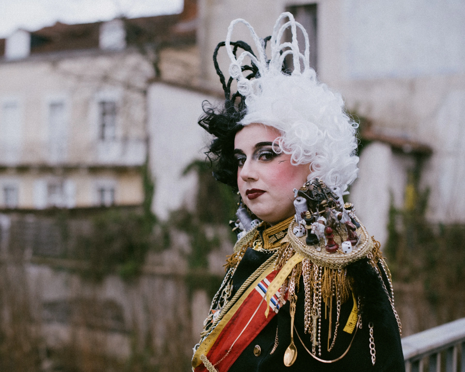 Portrait rapproché cosplay Cruella, coiffe sculpturale, bâtiments anciens de Périgueux en arrière-plan
