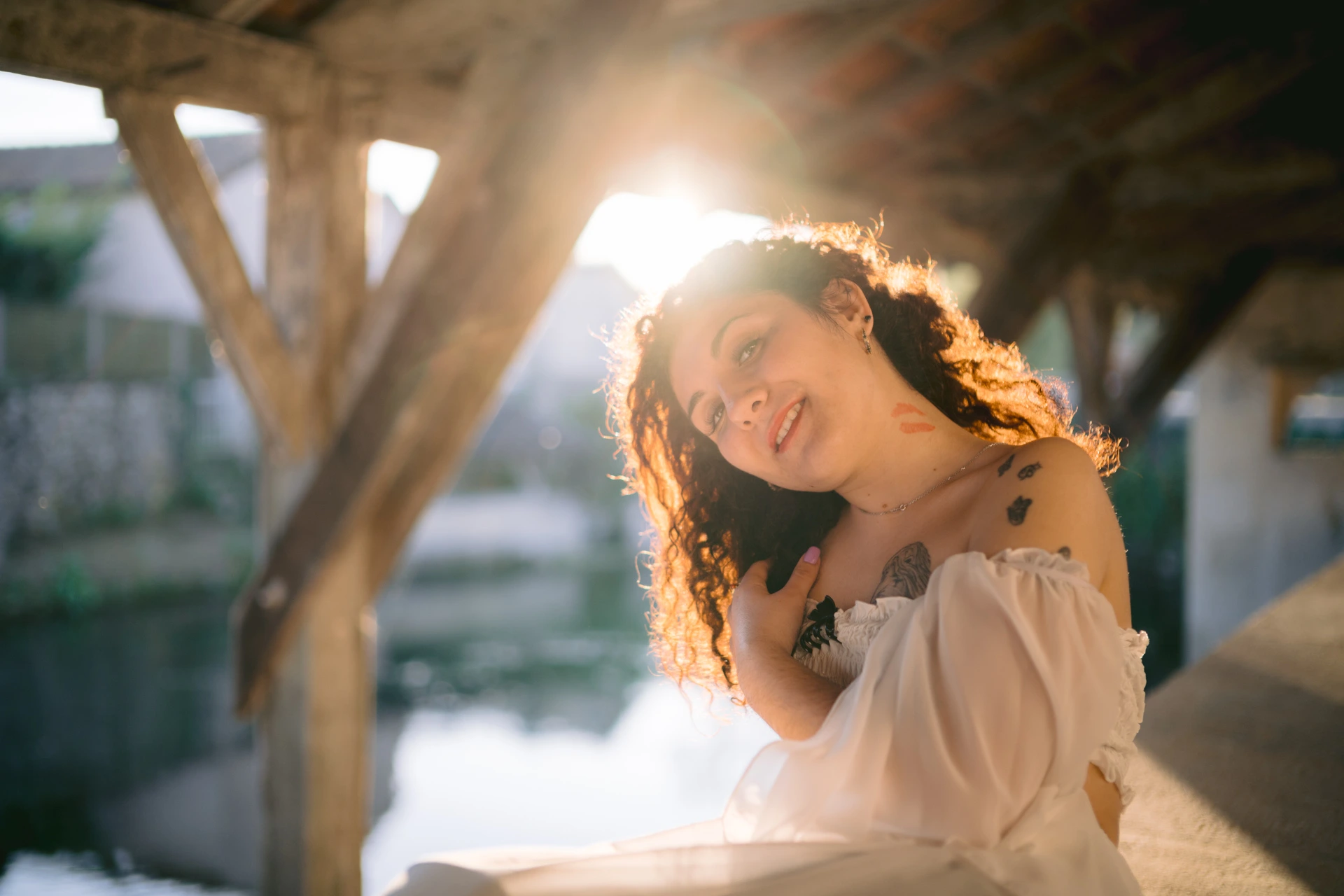 Photographe portrait Ruffec Charente - portrait femme sous le lavoir traditionnel au bord de l'eau, contre-jour et soleil couchant, ambiance Fine Art