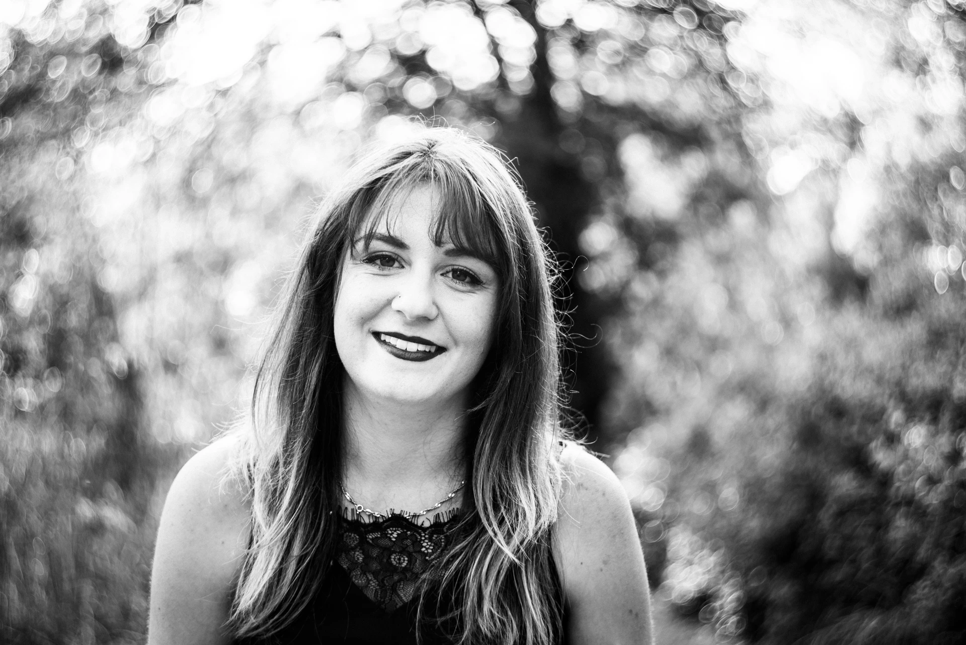Grand sourire sublimé par un bokeh tournoyant, portrait Fine Art Charente noir et blanc