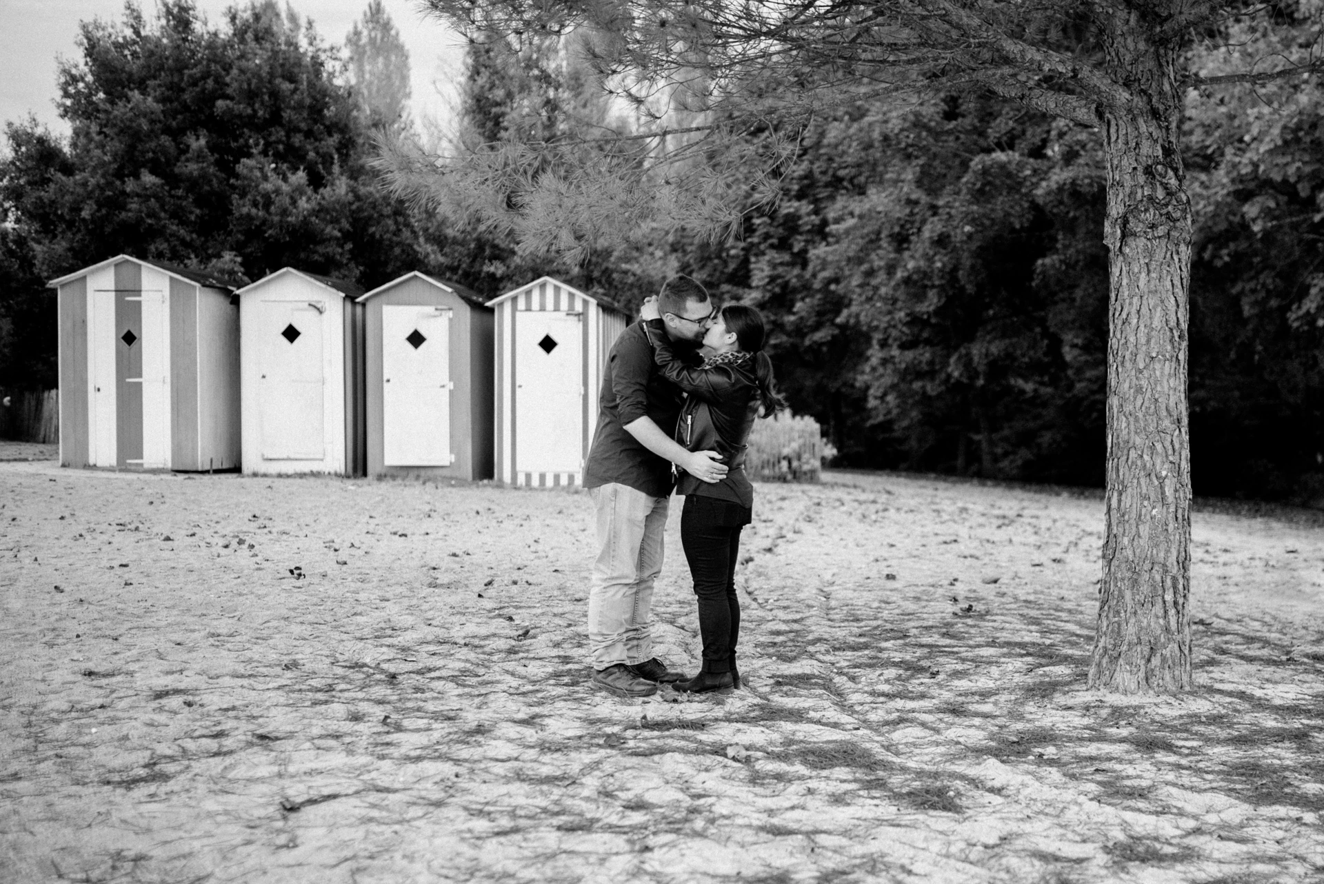 Baiser en noir et blanc devant des cabines de plage, photographe couple Charente