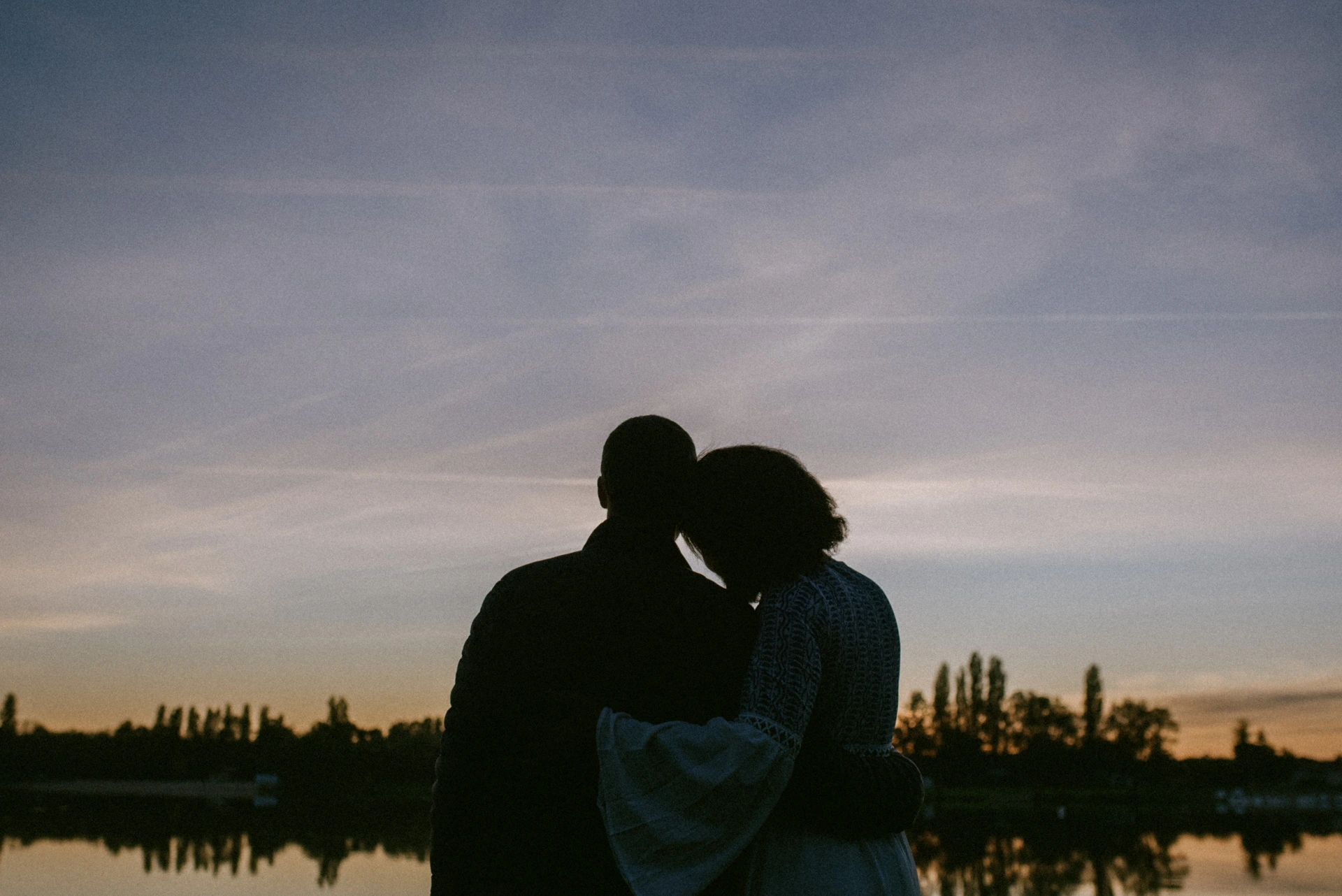Silhouette d'un couple enlacé face au coucher de soleil sur le lac de Saint-Yrieix-sur-Charente