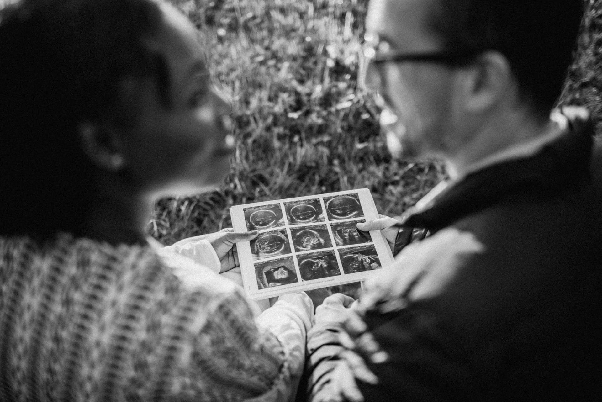 Couple regardant ensemble une image d'échographie en noir et blanc, photographe grossesse Charente