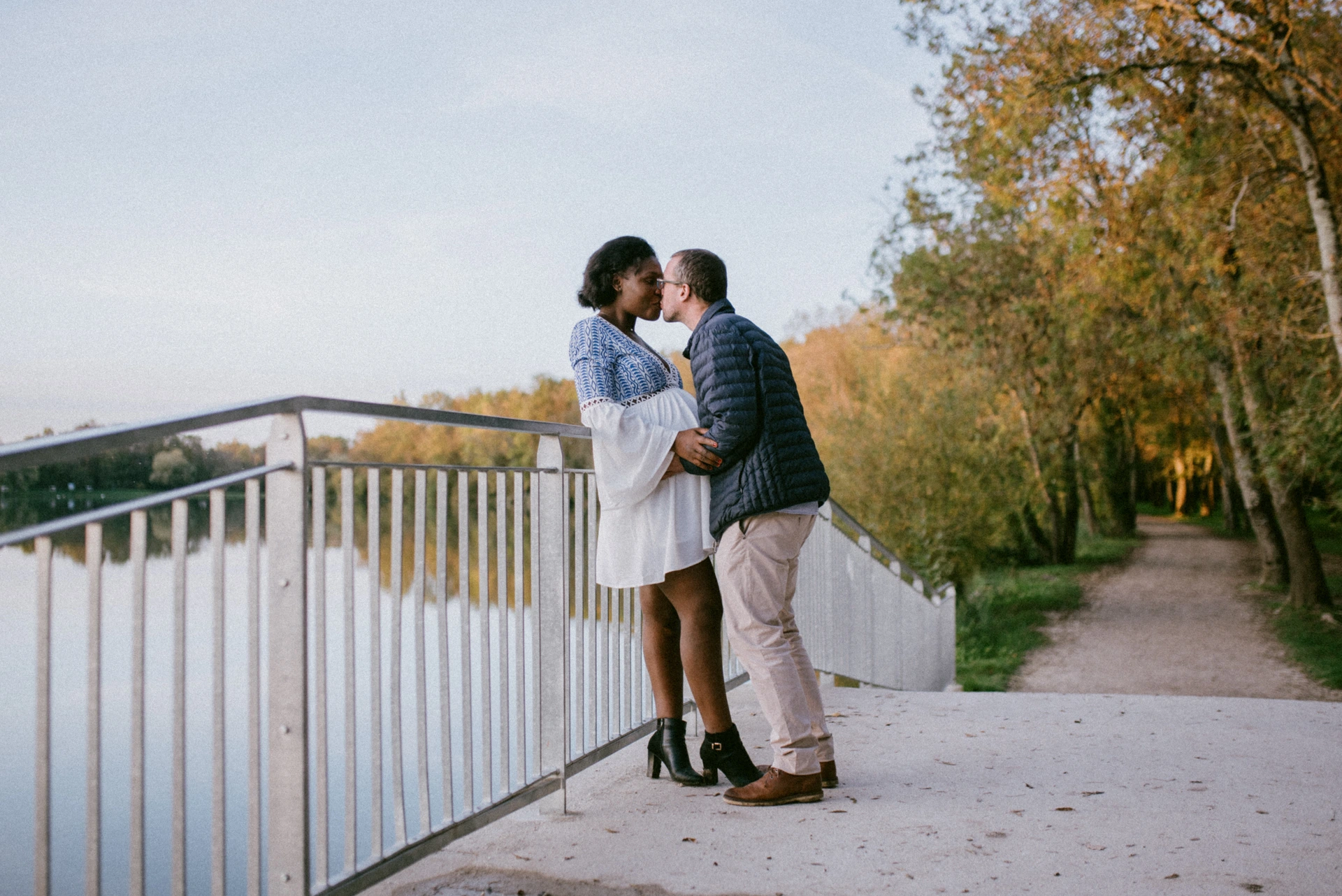 Couple s'embrassant sur un pont au bord du lac à la lumière du soir, Saint-Yrieix-sur-Charente
